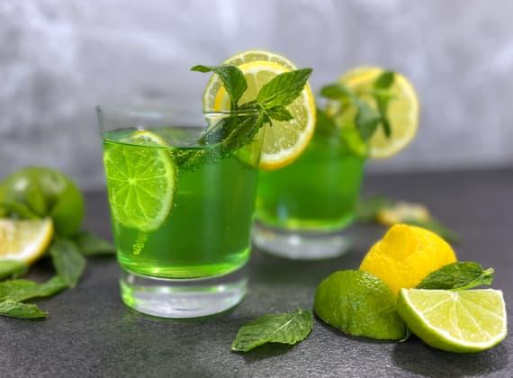 Zwei Wassergläser mit Limetten-Getränk mit Zitrone und Minze